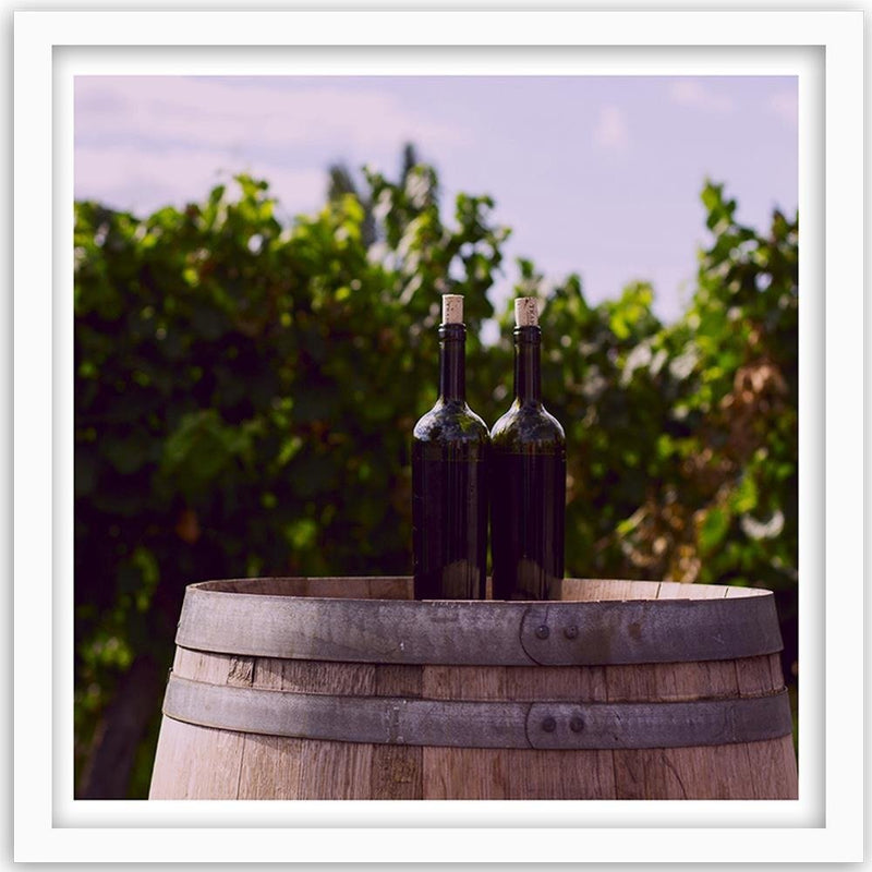 Glezna baltā rāmī - Bottles Of Wine On A Barrel 